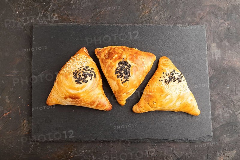 Homemade asian pastry samosa on black concrete background. top view, flat lay, close up