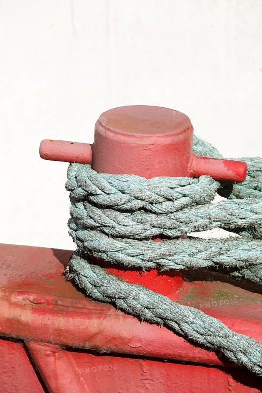 Red ship's bollard wrapped with ship's rope, mooring line, Germany, Europe