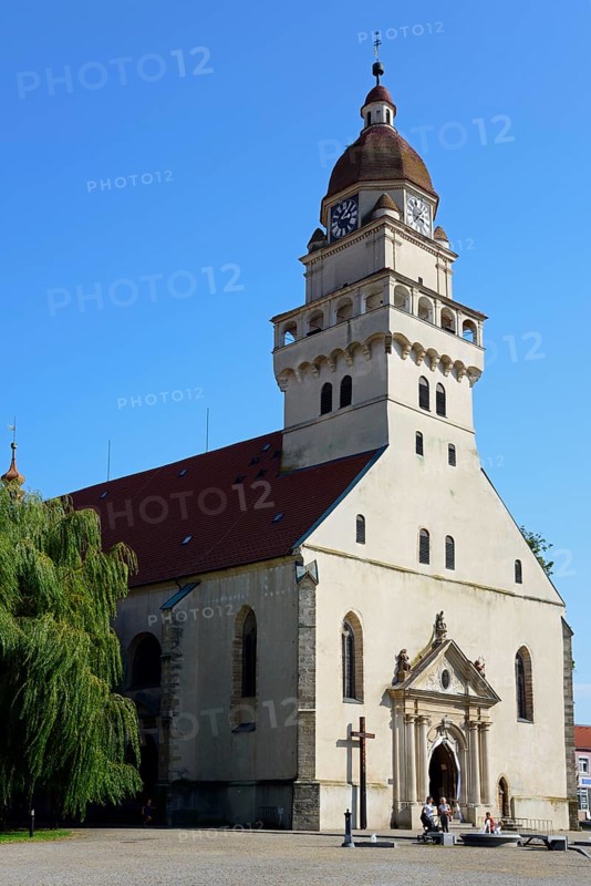 A sunny day illuminates a church with an onion dome and shade on the forecourt, Roman Catholic parish church of St Michael, Skalica, Skalica, Trnavsky kraj, Slovakia, Europe