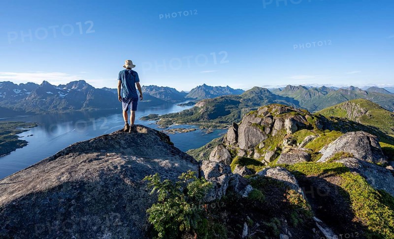 Mountaineer on the summit of Dronningsvarden or Stortinden, mountains and fjord Raftsund, Sonnenstern, Vesteralen, Norway, Europe