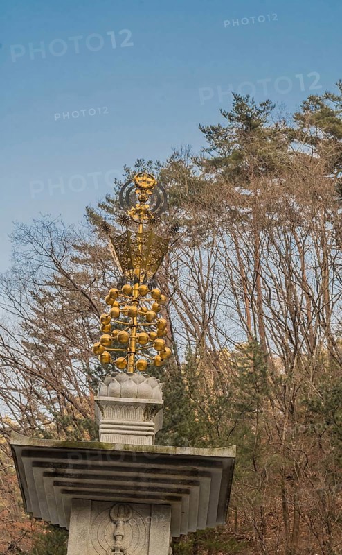 Golden ornament on top of stone carved pagoda at Buddhist temple in South Korea