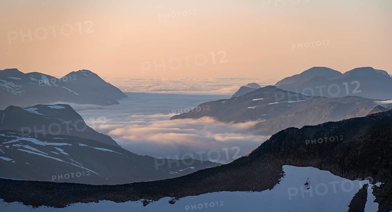 Mountain panorama with clouds in the valley, mountain peaks in soft light at sunset, view from the summit of Skala, Loen, Norway, Europe