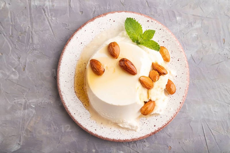 Ricotta cheese with honey and almonds on gray concrete background. top view, flat lay, close up