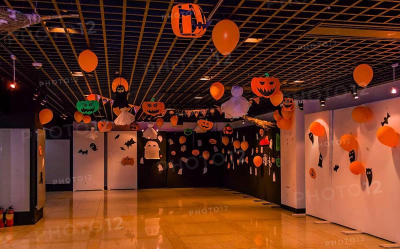Dimly lit room decorated with hand made Halloween decorations of ghost, jack-o-lanterns and balloons in South Korea