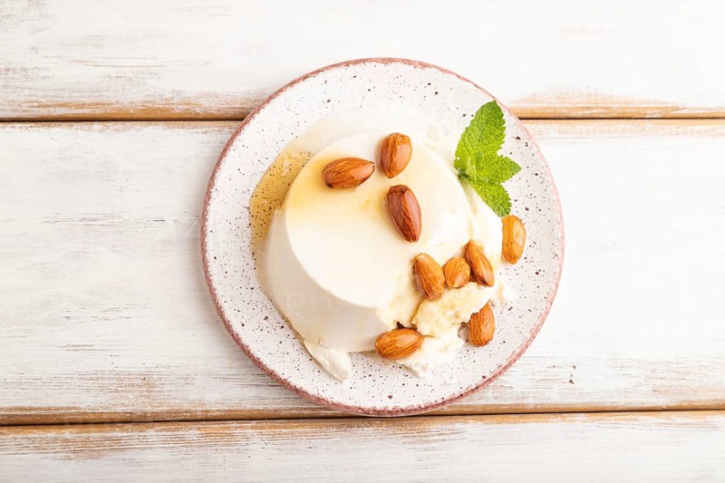 Ricotta cheese with honey and almonds on white wooden background. top view, flat lay, close up