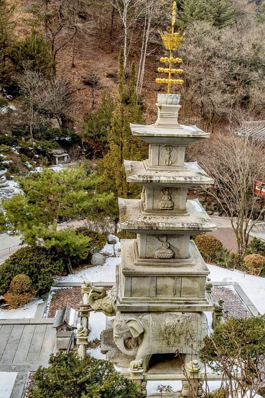 Four story stone carved pagoda on plinth of three elephants at Buddhist temple in South Korea