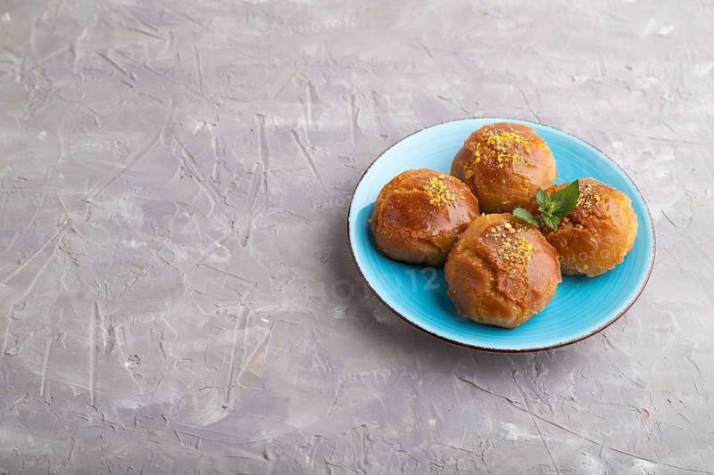 Homemade traditional turkish dessert sekerpare with almonds and honey on gray concrete background. side view, copy space