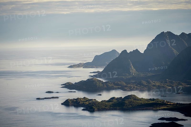 View of the coast in Ulvagsundet fjord and mountains in the evening light, Hurtigruten cruise ship in the fjord, view from the summit of Dronningsvarden or Stortinden, Vesteralen, Norway, Europe