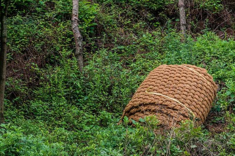 Closeup of thatch rope mat laying rolled up on ground in South Korea