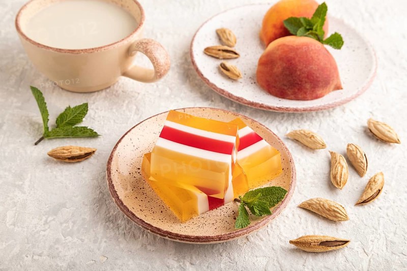 Almond milk and peach jelly on gray concrete background. side view, close up
