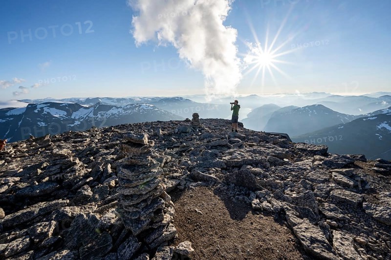 Mountaineers photographed, at the summit of Skala with cairns, view of mountain landscape and fjord Faleidfjorden, Sun Star, Loen, Norway, Europe