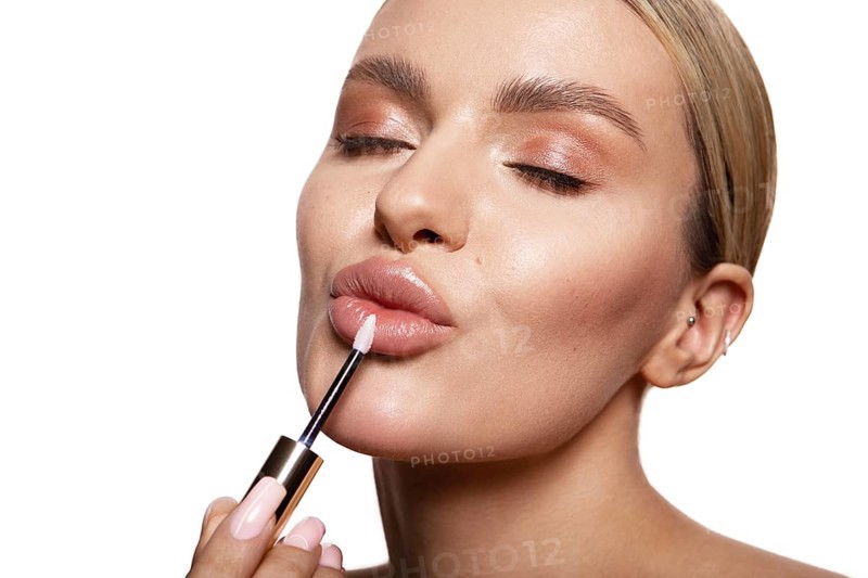Beauty portrait of model with natural make-up holding a jar of cream. Fashion shiny highlighter on skin, sexy gloss lips make-up High quality photo. Holds lipstick