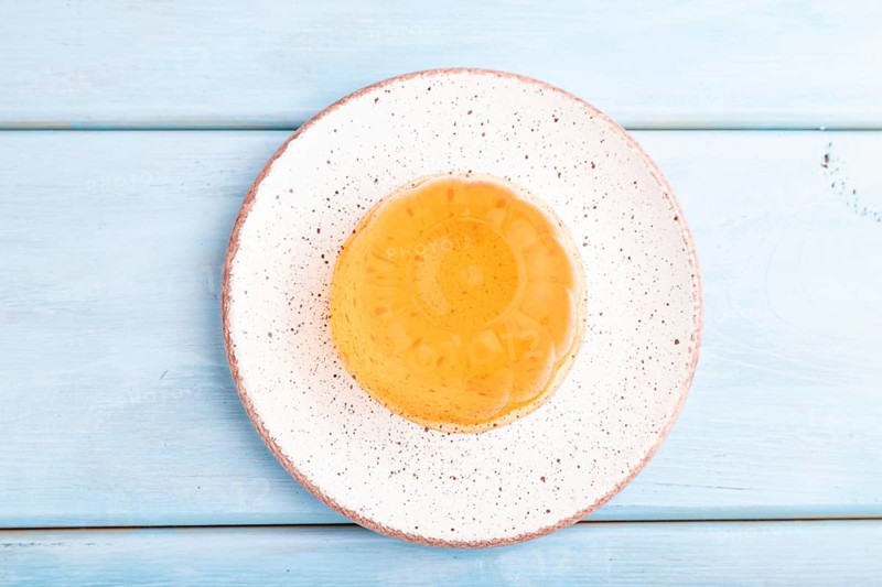 Apricot orange jelly on blue wooden background. top view, flat lay, close up