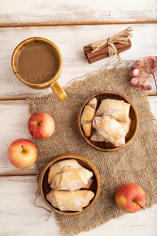 Homemade sweet cookie with apple jam and cup of coffee on white wooden background and linen textile. top view, flat lay, close up