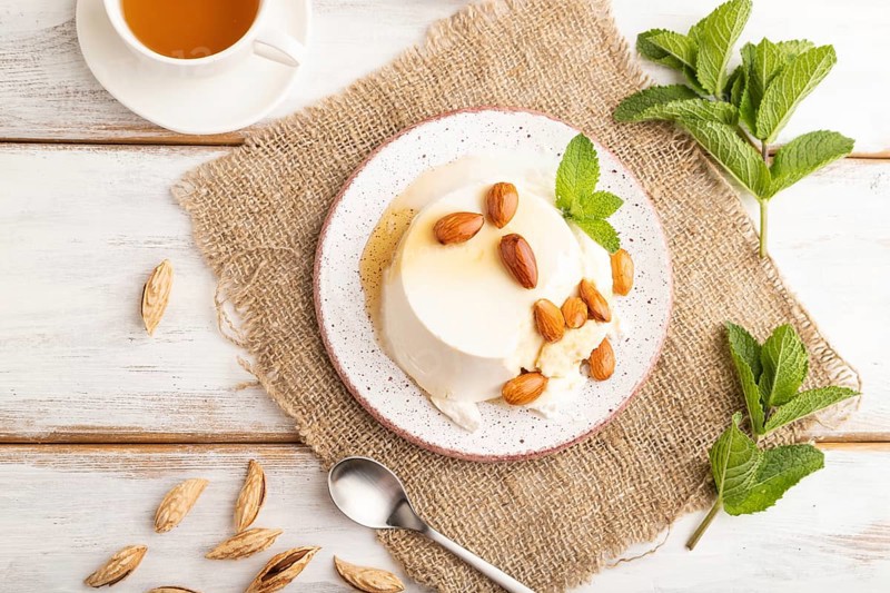 Ricotta cheese with honey and almonds on white wooden background and linen textile. top view, flat lay, close up