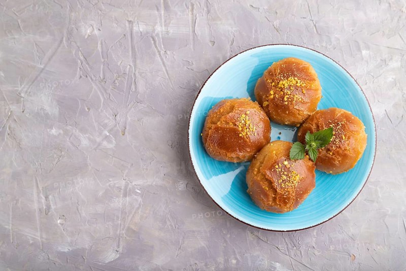 Homemade traditional turkish dessert sekerpare with almonds and honey on gray concrete background. top view, flat lay, copy space