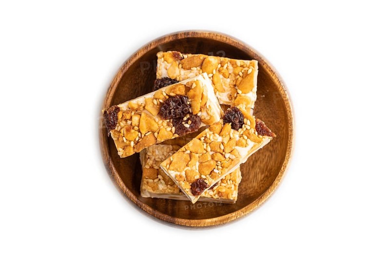 Traditional candy nougat with nuts and sesame isolated on white background. top view, flat lay, close up