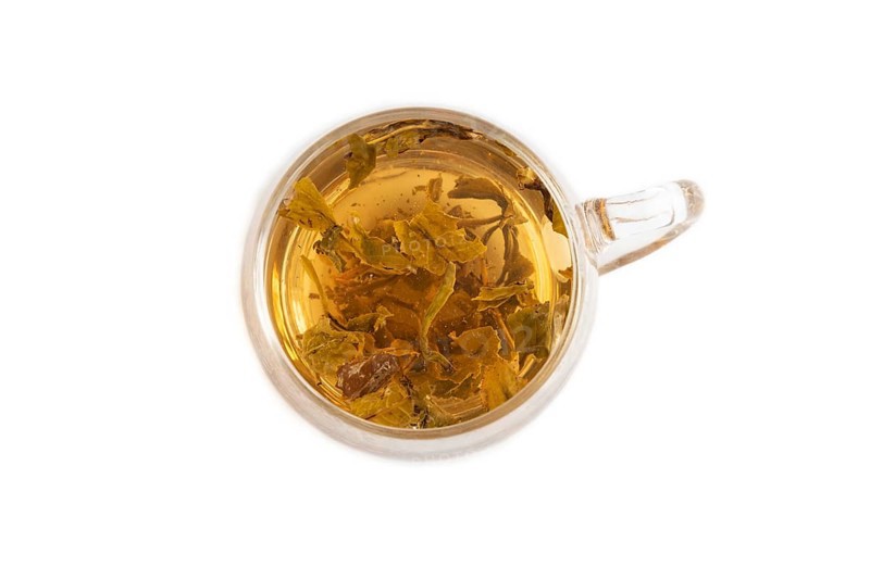 Red tea with herbs in glass cup isolated on white background. Healthy drink concept. Top view, flat lay, close up