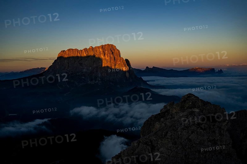 Sunrise over a sea of fog with the peaks of the Sella massif in the background, Corvara, Dolomites, Italy, Europe