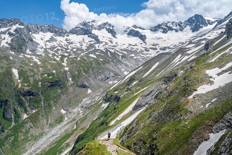 Mountaineer on hiking trail in picturesque mountain landscape, in the background mountain peak Grosser Loeffler and Oestliche Floitenspitze with glacier Floitenkees, valley Floitengrund, Berliner Hoehenweg, Zillertal Alps, Tyrol, Austria, Europe