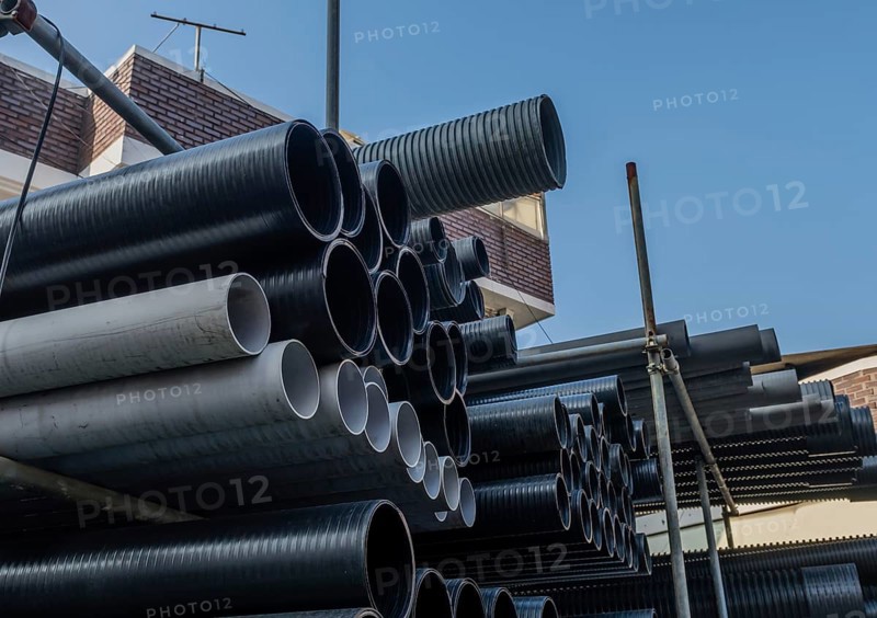 Large diameter pvc pipes stored on metal scaffolding outside