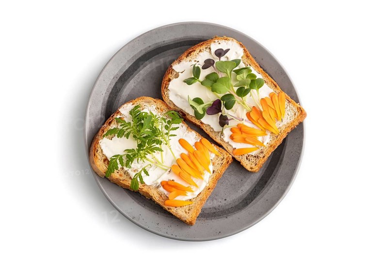 White bread sandwiches with cream cheese, calendula petals and microgreen radish and tagetes isolated on white background. top view, flat lay, close up
