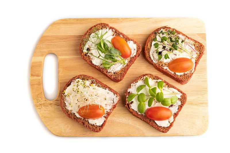 Red beet bread sandwiches with cream cheese, tomatoes and microgreen isolated on white background. top view, flat lay, close up