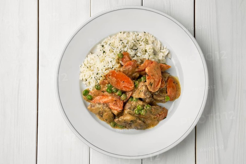 Portion of beef goulash with carrot and rice, top view