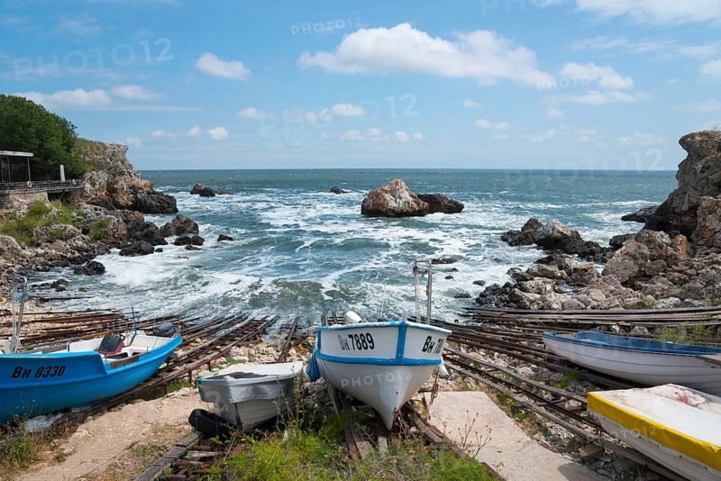 Boats on a coastline with rough seas and rocky outcrops in the background, harbour, Tyulenovo, Shabla, Dobrich, Black Sea, Bulgaria, Europe