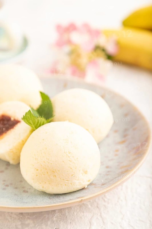 Japanese rice sweet buns mochi filled with jam and cup of coffee on a gray concrete background. side view, close up, selective focus