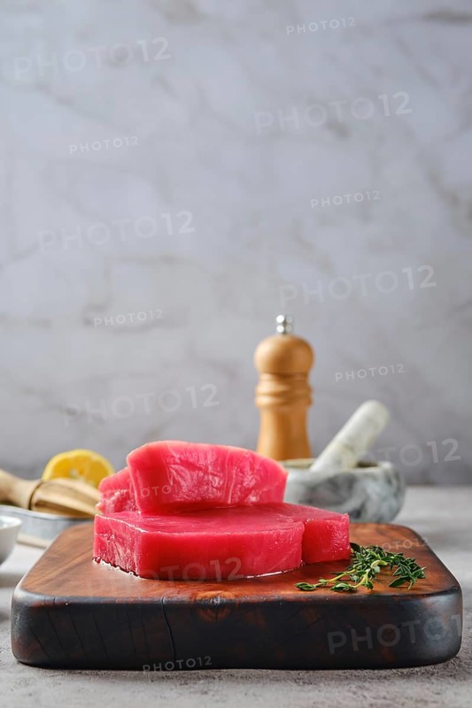 Low angle view of raw ahi tuna steak on cutting board with spice