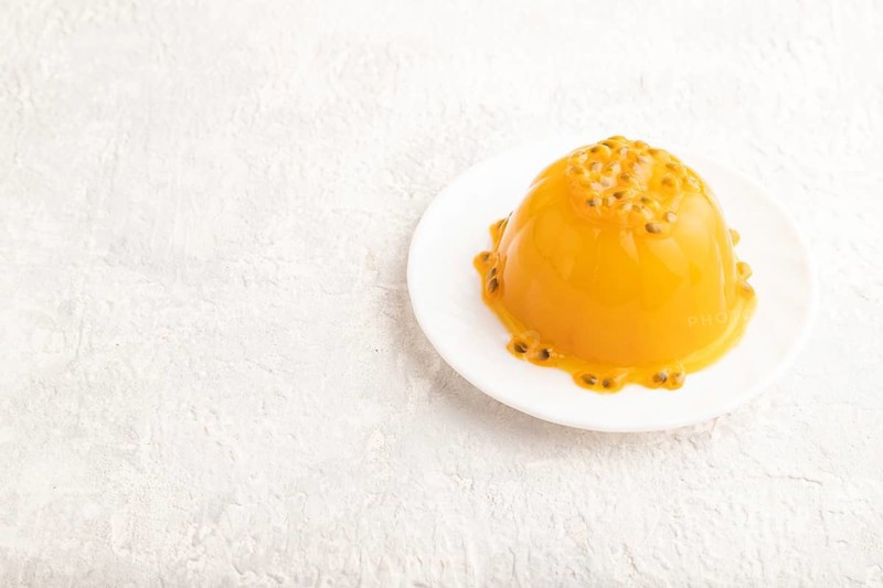 Mango and passion fruit jelly on gray concrete background. side view, copy space