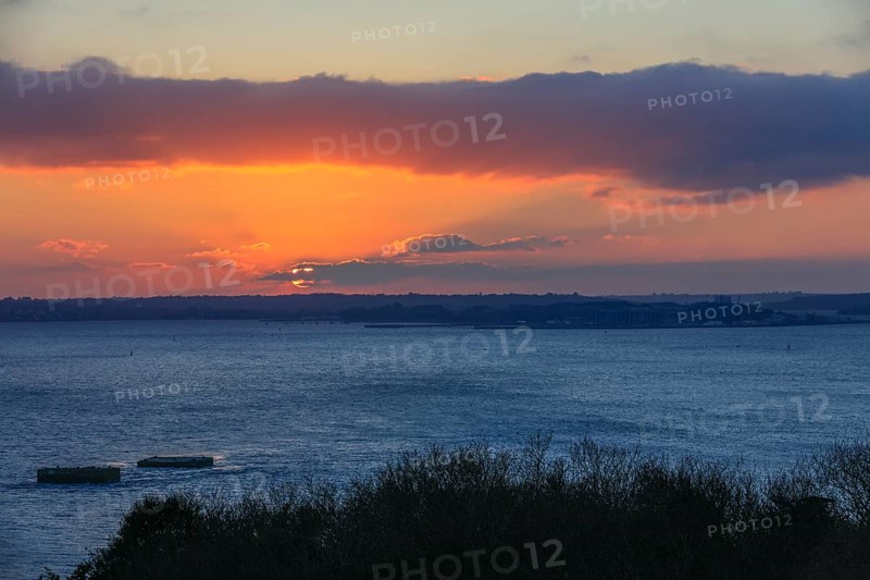 View at sunset from the Pointe de l'Armorique over the bay Rade de Brest, in the background the peninsula Presqu'ile de Crozon with the Ile Longue, base strategic nuclear submarines of the French Navy, on the left the two dolphins built by the German Navy during the Second World War, where the battleship Bismarck was supposed to dock, peninsula Plougastel-Daoulas, department Finistere Penn-ar-Bed, region Bretagne Breizh, France, Europe