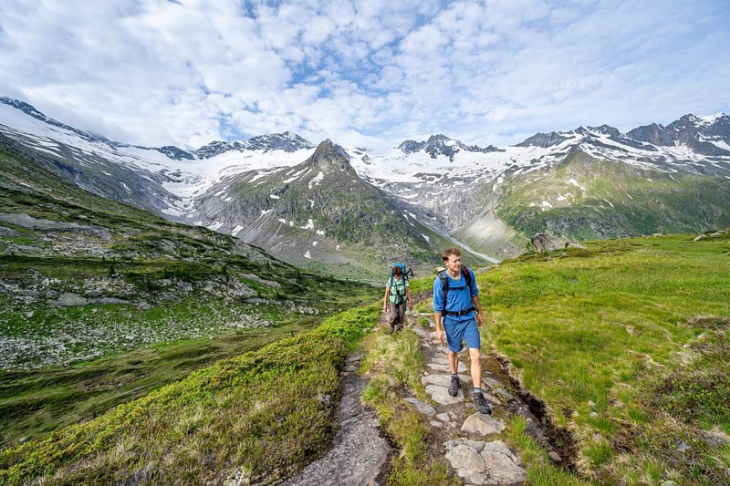 Two mountaineers on a hiking trail in a picturesque mountain landscape, mountain peaks with snow and glacier Hornkees and Waxeggkees, summit Grosser Moeseler and Hornspitzen, Berliner Hoehenweg, Zillertal Alps, Tyrol, Austria, Europe