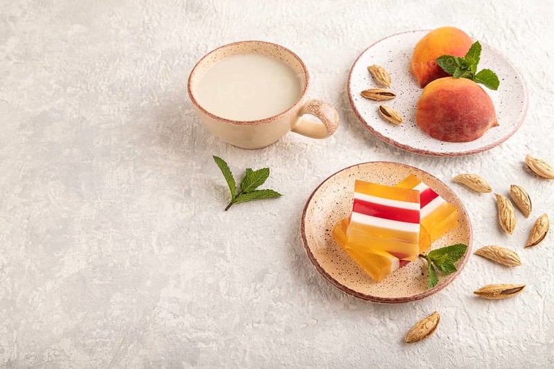 Almond milk and peach jelly on gray concrete background. side view, copy space
