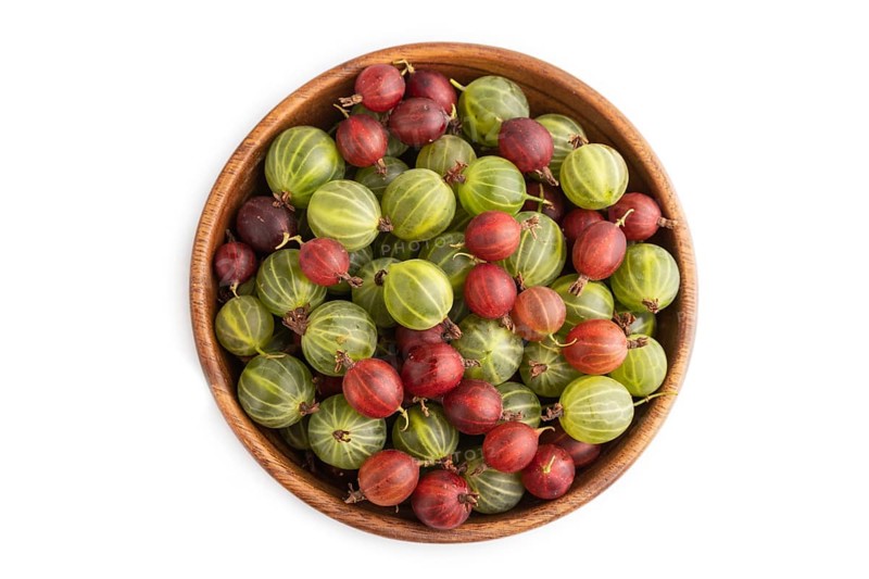 Fresh red and green gooseberry in wooden bowl isolated on white background. top view, flat lay, close up