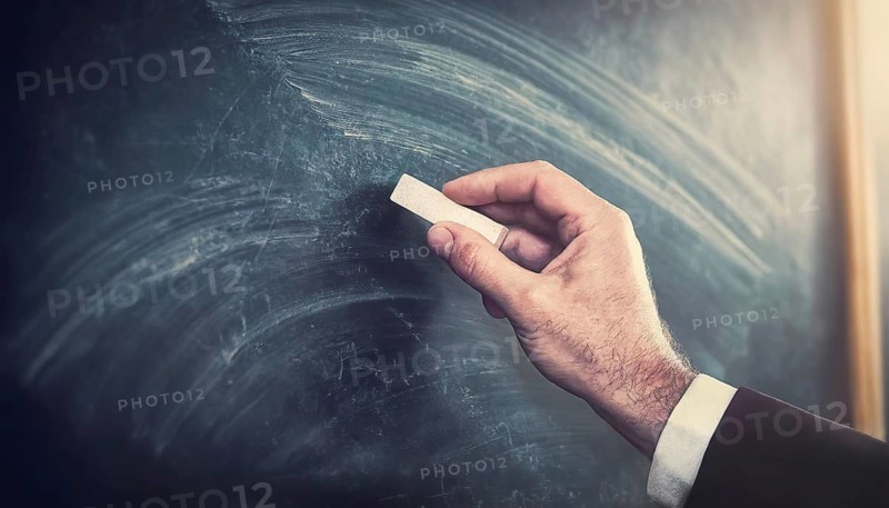 Closeup teacher hand holding a piece of chalk starts writing on the blank blackboard. Businessman arm in front of a blank chalkboard begins drawing. Business and education background with copy space. Generative AI art, AI generated