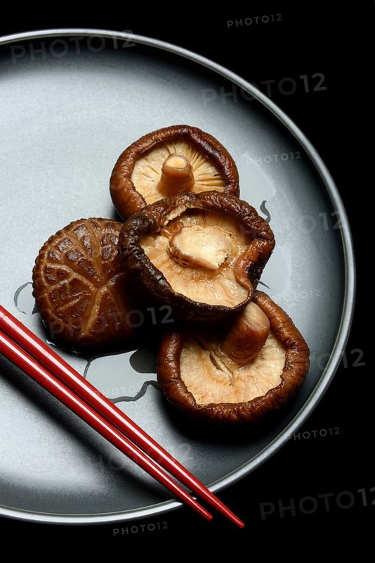 Dried and soaked shiitake mushrooms on a plate with chopsticks