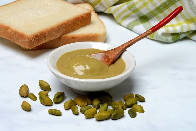 Pistachio cream in small bowls and slices of bread, pistachio