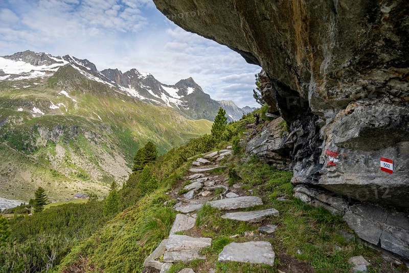 Hiking trail under a rocky outcrop in a picturesque mountain landscape, Berliner Hoehenweg, Zillertal Alps, Tyrol, Austria, Europe