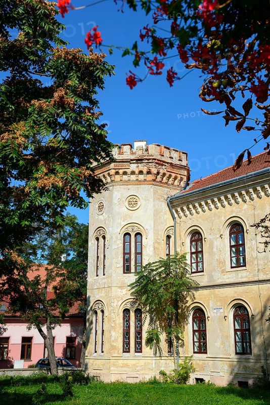 Historic building with battlements under a clear blue sky, surrounded by nature and blooming flowers, Officers' Palace, Komarno, Komarom, Komorn, Nitriansky kraj, Slovakia, Europe