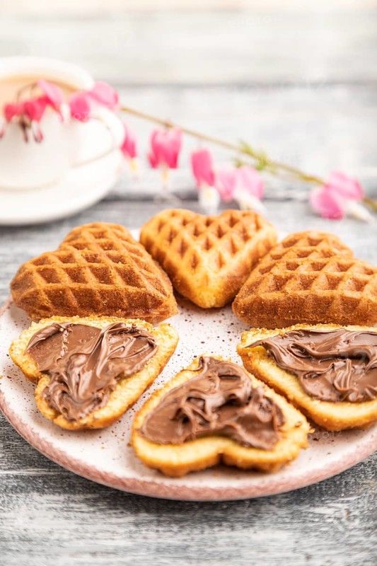 Homemade waffle with chocolate butter and cup of coffee on a gray wooden background. side view, selective focus, close up