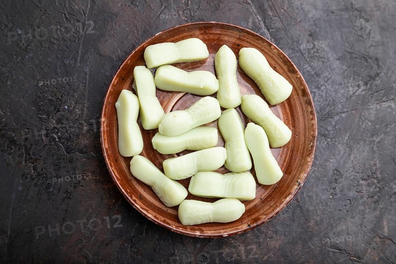 Jelly celery candies on black concrete background, top view, flat lay, close up