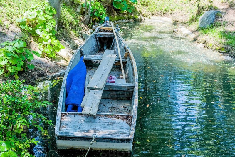 Wooden row boat at shore of lake in Japanese Shukkeien Gardens in Hiroshima, Japan, Asia
