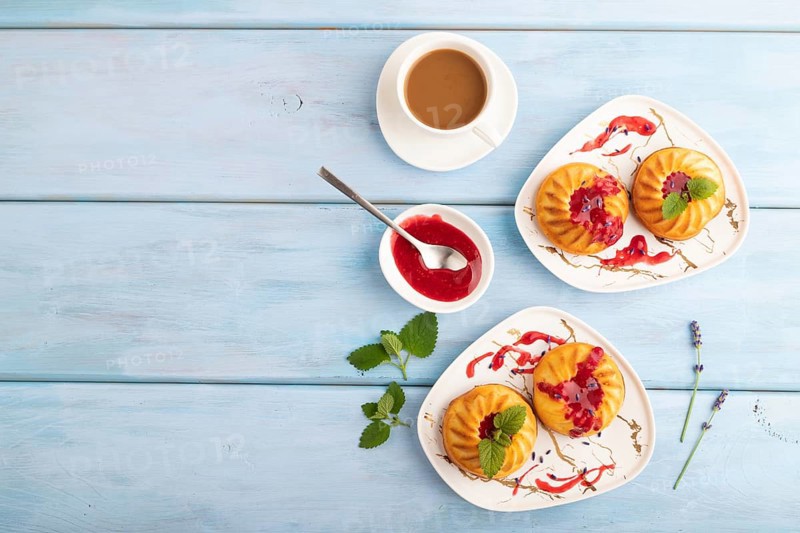 Semolina cheesecake with strawberry jam, lavender, cup of coffee on blue wooden background. top view, flat lay, copy space