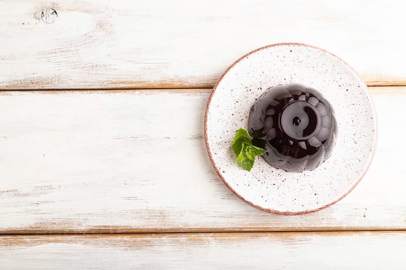 Black currant and grapes jelly on white wooden background. top view, flat lay, copy space