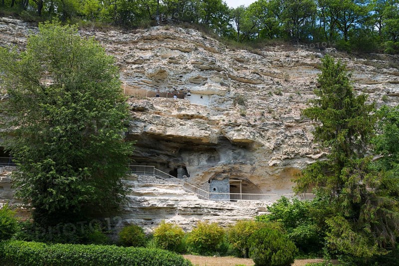 View of cave dwellings in a large rock face surrounded by trees and greenery, Aladja Monastery in 2 levels, Aladja Monastery, Aladzha Monastery, medieval rock monastery, cave monastery in limestone cliff, Varna, Black Sea coast, Bulgaria, Europe