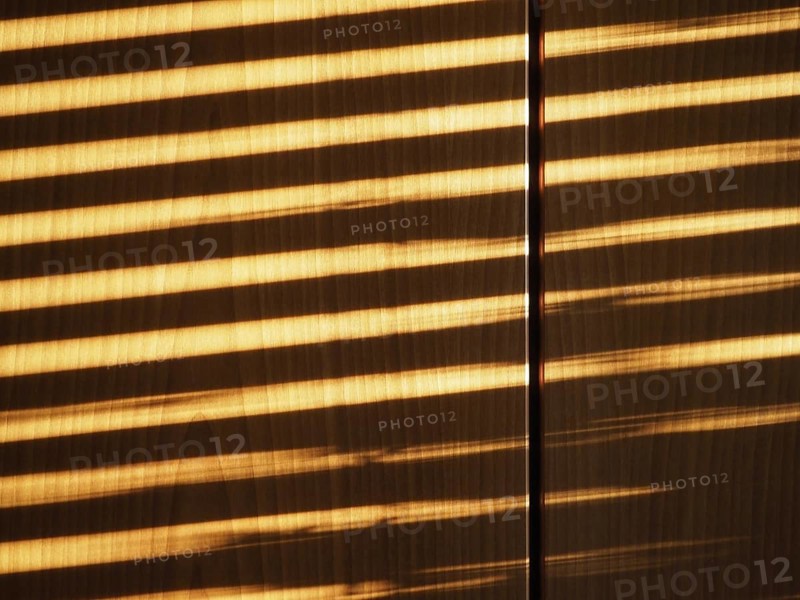 Blinds shadow on wooden wall background