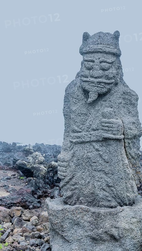 Ancient stone carved figure of sea god on coast of Jeju island, South Korea, Asia