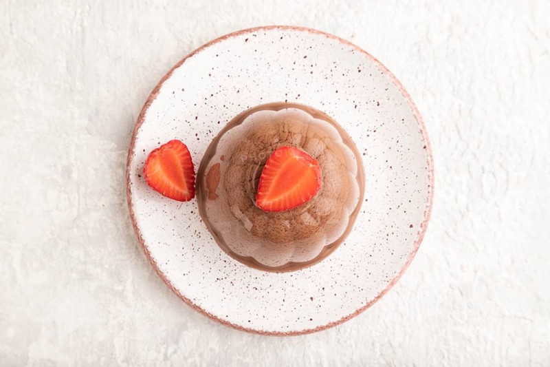 Chocolate jelly with strawberry on gray concrete background. top view, flat lay, close up
